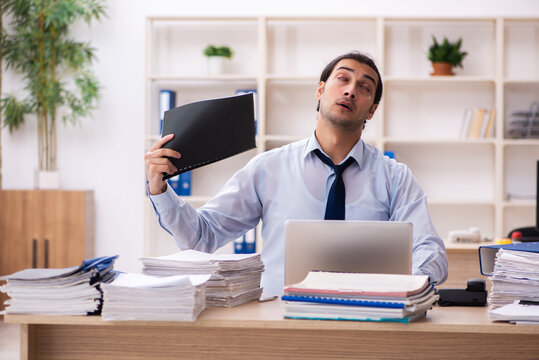 Young Male Employee And Too Much Work In The Office