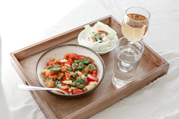 Mixed Bell-pepper Salad with Lettuce egg wrap on a brown tray in room with plants and sunshine through the window
