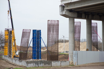 construction of a road bridge with reinforced concrete support columns, across the railway