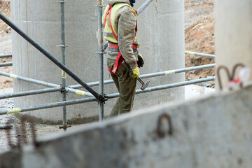 Construction worker with metal hammer on scaffolding background