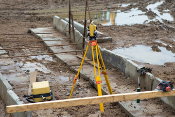 optical level on a tripod in a construction area