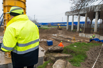 Construction supervisor stand with his back at a construction site