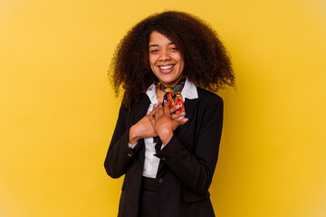 Young African American air hostess isolated on yellow background has friendly expression, pressing...