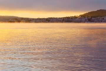Steaming Lake Storsjön in the light of sunset in late autumn