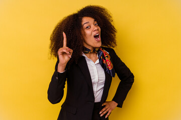 Young African American air hostess isolated on yellow background having an idea, inspiration concept.