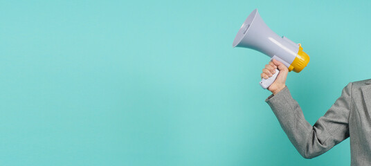 Hand is hold megaphone and wear grey suit on green or mint or Tiffany Blue  background.