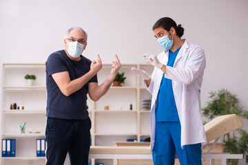Old man visiting young doctor in covid-19 vaccination concept