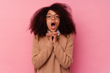 Young african american woman isolated on pink background praying for luck, amazed and opening mouth looking to front.