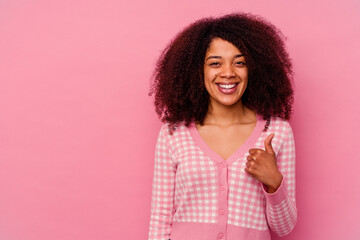 Young african american woman isolated on pink background smiling and raising thumb up