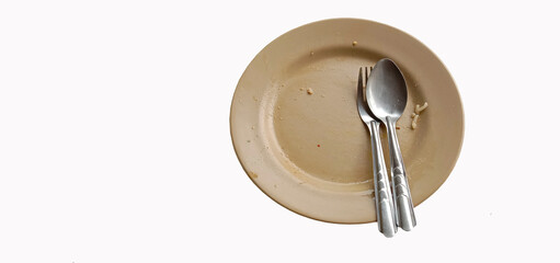 Plates and spoons and utensils have food scraps on a white background.
