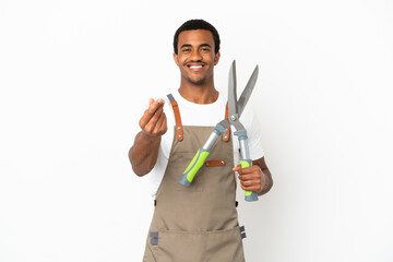 African American gardener man holding pruning shears over isolated white background making money gesture