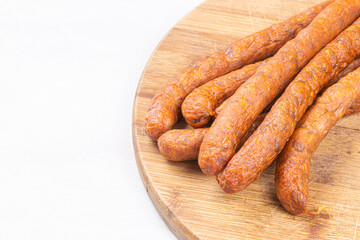 Fresh raw smoked sausages on the wooden cutting board