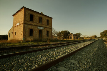 Antigua estación de ferrocarril abandonada. Apeadero de Los Hitos (Albacete). Edificio de la estación y aseos anexos. Vía del tren actualmente en uso de la línea Chinchilla-Cartagena.
