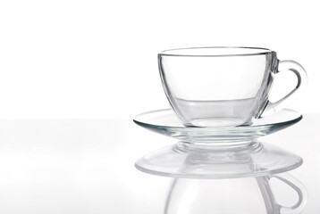 Glass cup standing on table isolated on white background, close-up