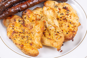 Delicious chicken breasts fried and served with fried sausages on the plate