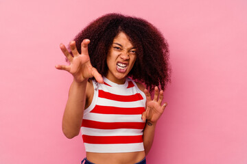 Young african american woman isolated on pink background upset screaming with tense hands.