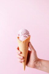 Female hand holding the ice cream, pink background - 428643752