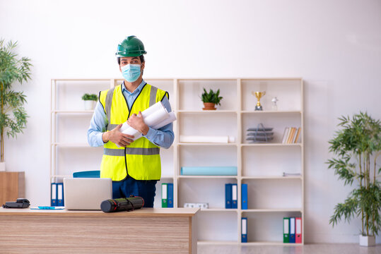Young male architect working in the office during pandemic