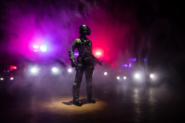 Fototapeta premium Anti-riot police give signal to be ready. Government power concept. Police in action. Smoke on a dark background with lights. Blue red flashing sirens. Dictatorship power