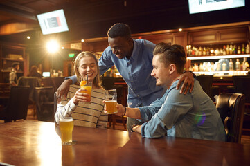 Three friends drinks alcohol and having fun in bar