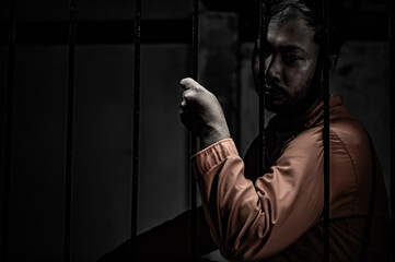 Asian man desperate at the iron prison,prisoner concept,thailand people,Hope to be free,Serious...
