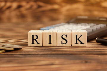 Word risk. Business concept on wooden cubes and dollars background