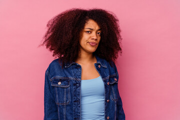 Young african american woman isolated on pink background sad, serious face, feeling miserable and...