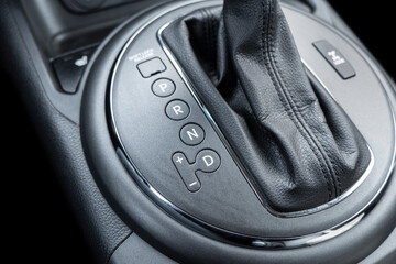 Obraz na płótnie Canvas Automatic gear stick of a modern car. Modern car interior details. Close up view. Car inside. Automatic transmission lever shift. Black leather interior with stitching