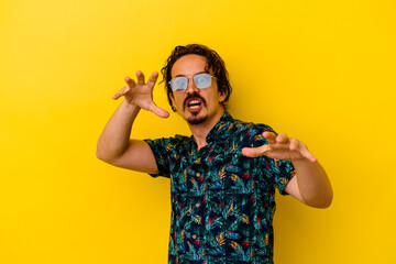 Young caucasian man wearing summer clothes isolated on yellow background being shocked due to an imminent danger