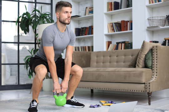 Handsome Man Doing Sport Exercise With Kettlebell At Home. Concept Of Healthy Life.