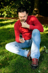 Pensive Man with Cellphone in Park