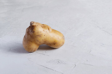 Ugly potatoes in the shape of a heart on a light gray background. Horizontal orientation