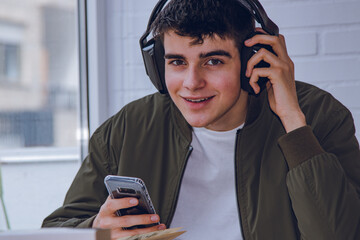 teen at home with headphones and mobile phone