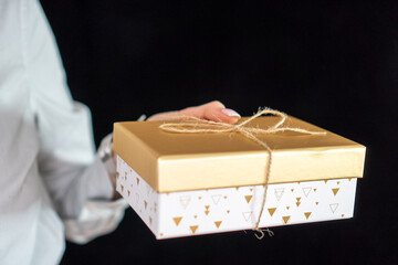 girl with manicure holding a gold gift