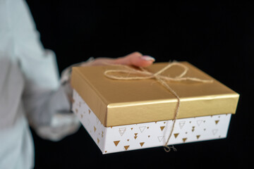 girl with manicure holding a gold gift