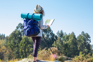 woman with backpack and map hiking