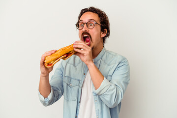 Young caucasian man holding a sandwich isolated on white background