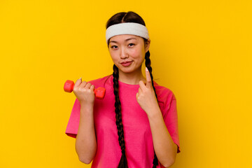 Young sport chinese woman isolated on yellow background pointing with finger at you as if inviting come closer.