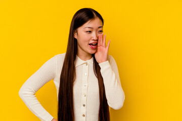 Young chinese woman isolated on yellow background shouting excited to front.