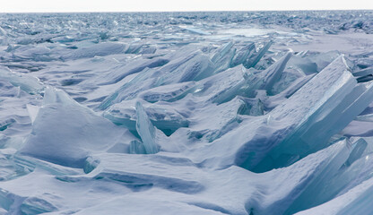 Scenic winter lake Baikal landscape with huge pressure ridge transparent ice blocks on the surface