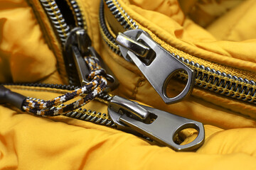 The lock with a zipper is close-up on the clothes of yellow color. Zipper with lock.