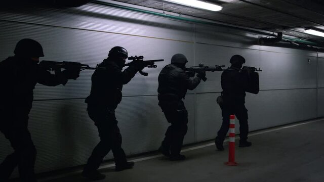 Soldiers storming building. Special assault team aiming targets on firearms