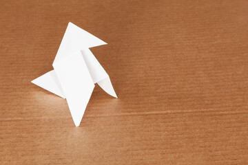 Paper little bird on cardboard surface