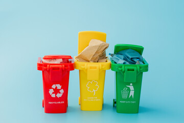 Yellow, green and red recycle bins with recycle symbol on blue background. Keep city tidy, Leaves...