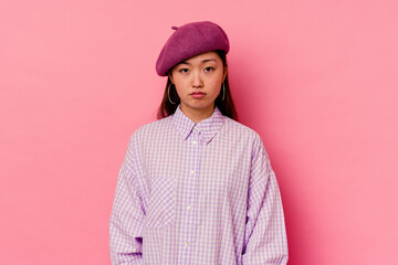 Young chinese woman isolated on pink background sad, serious face, feeling miserable and displeased.