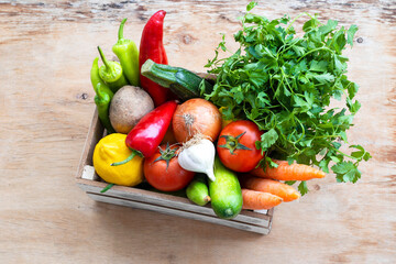 Fresh Vegetables in basket on wooden table. Top view.