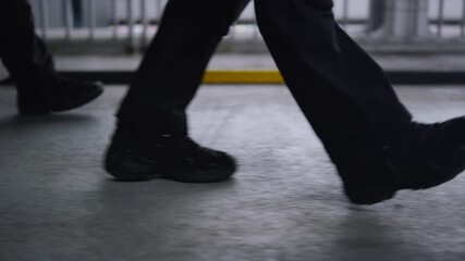 Special forces squad moving on bridge. Men in black shoes walking on road