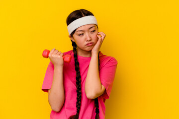 Young sport chinese woman isolated on yellow background