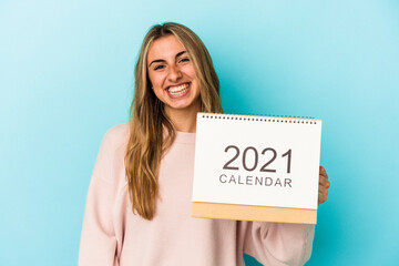 Young blonde caucasian woman holing a calendar isolated happy, smiling and cheerful.