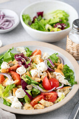 Healthy summer italian salad with mozzarella cheese, tomatoes, croutons and lettuce on a plate